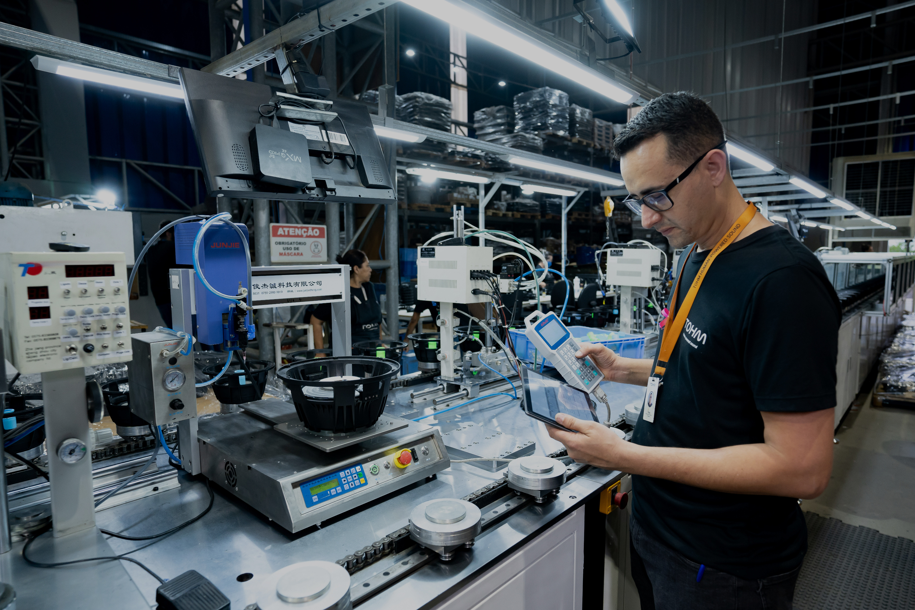 Especialista técnico da Tohm operando equipamento de medição em linha de produção.